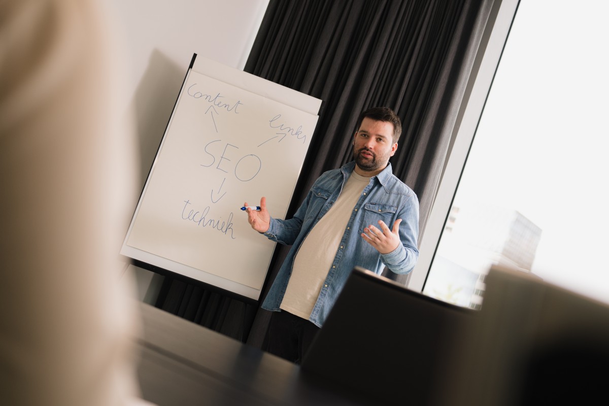 SEO specialist Mathias Noyez legt met behulp van een flipchart uit wat de 3 SEO pijlers zijn: content, autoriteit en techniek.